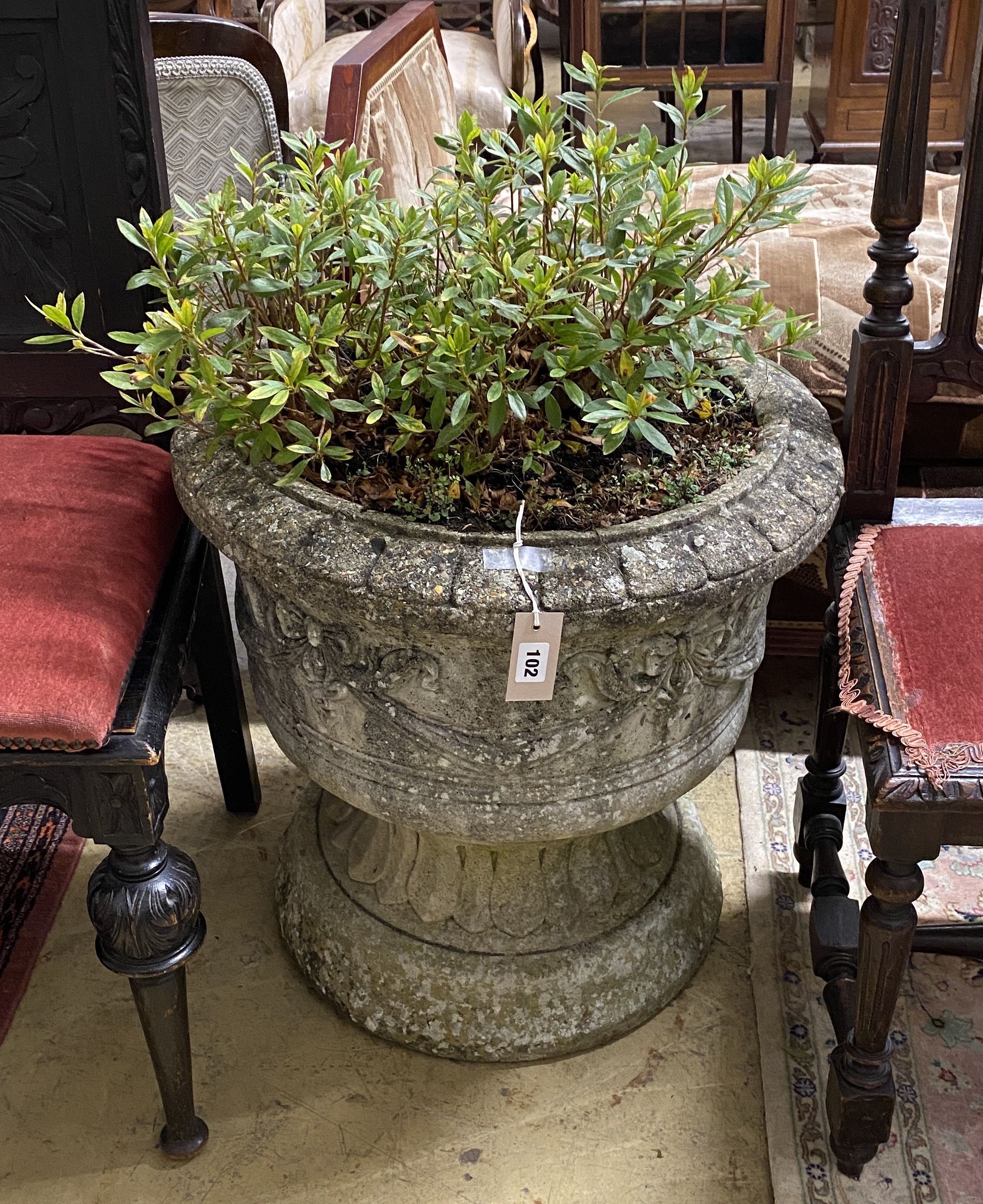 A circular reconstituted stone garden planter with ribbon fold moulded body, diameter 58cm, height 59cm